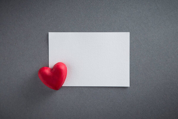 День святого Валентина фон с красным шоколадом формы сердца и белой бумаги из верхнего вида. Копирование пространства
