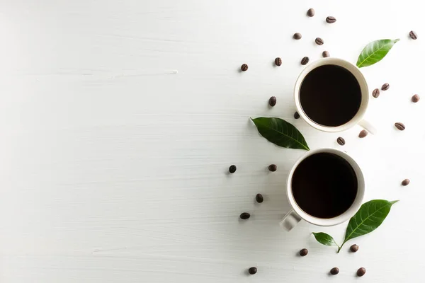 Cangkir komposisi kreatif kopi dengan biji kopi dan daun di — Stok Foto
