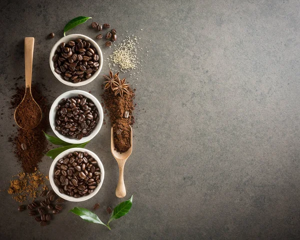 Diferentes variedades de grãos de café com açúcar e folha verde em — Fotografia de Stock