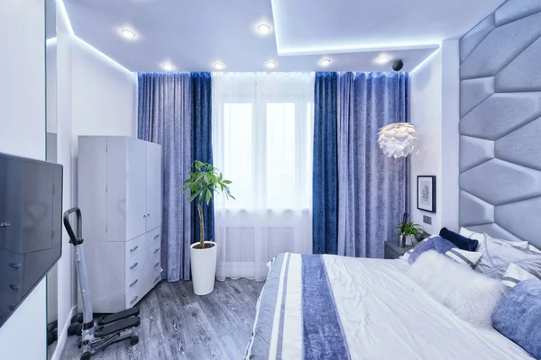 Modern design bedroom interior in gray and blue tones in a luxurious apartment.