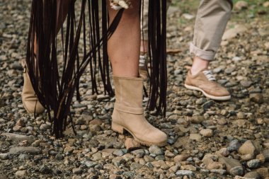 Gelin ve damat bir dağ yolundalar. Bir adam ve bir kadın kayalık bir yolda rahat ayakkabılarla yürüyorlar.