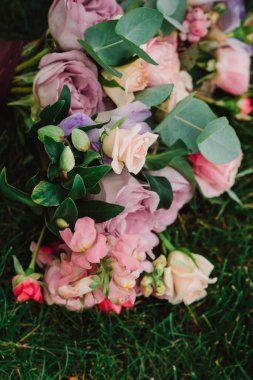 Güzel düğün buketi sonbahar yapraklarında yeşil çimlerin üzerinde yatıyor.