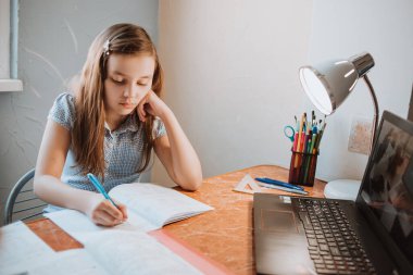 CoVid-19 karantinası sırasında evde ödev yapan kız bilgisayarla uzaktan öğrenme, okul ödevi yapan bir çocuk. Çocuklar evde kaldı..