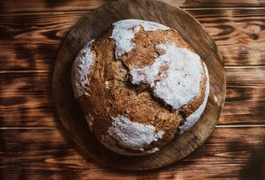 Tahıllı Ekmek Ekmeği. Koyu ahşap masanın üzerinde ev yapımı bir somun ekmek. Ev yapımı Somun Ekmek. Düzleştir