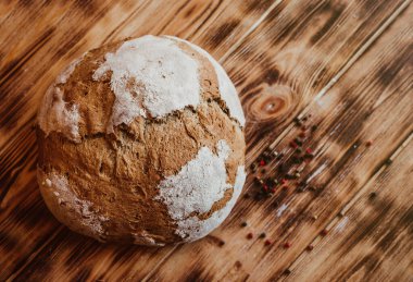 Tahıllı Ekmek Ekmeği. Ev yapımı bir somun ekmek. Koyu, ahşap bir masa. Baharatlı ev yapımı bir somun ekmek. Genel bakış. Test için doğru yer.