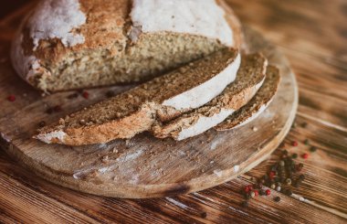 Tahıllı Ekmek Ekmeği. Ev yapımı bir somun ekmek. Koyu, ahşap bir masa. Baharatlı ev yapımı bir somun ekmek. Genel bakış. Test için doğru yer.