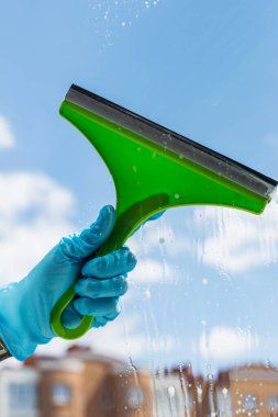 Gökyüzü arka planındaki pencereler için insan eli temizleme aracı. Temizlik kavramı