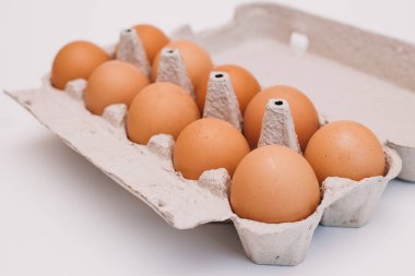 Karton kutuda on yumurta. Beyaz bir arkaplanda izole edilmiş.
