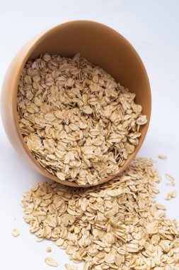 Tabakta yulaf ezmesi ve beyaz bir arka plana serpilmiş. Beyaz arkaplanda izole