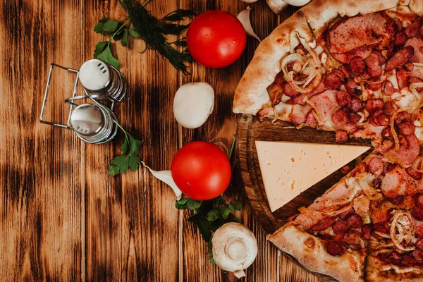 Ahşap arka planda sosisli pizza. Peynirli, domatesli, sarımsaklı, mantarlı. Düz Yatay