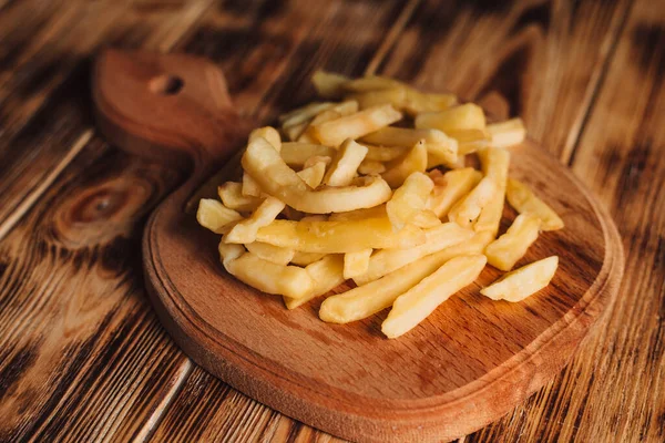 Patates kızartması ahşap tabakta yatıyor.