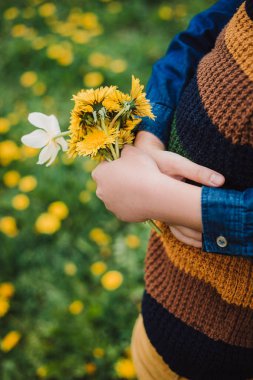 Kız elinde çiçeklerle bir oğlana sarılıyor. Çiçek arkaplanı
