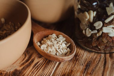 Tahta bir arka planda tahta kaşıkta yulaf ezmesi ve kurutulmuş meyve. Sağlıklı beslenme ve sağlıklı yaşam tarzı kavramı.