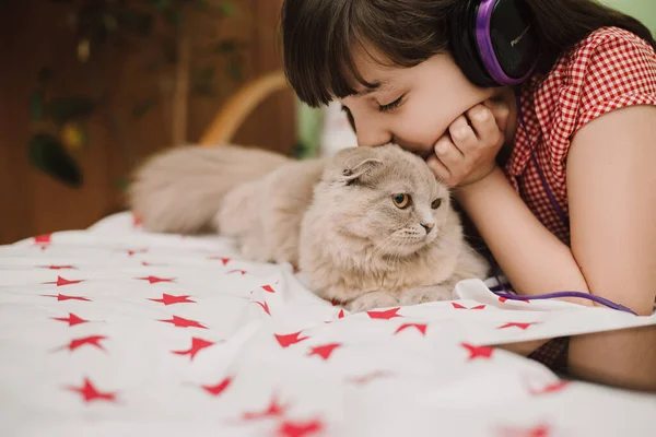 Mädchen Hört Musik Mit Kopfhörern Und Schöne Flauschige Katze Liegt — Stockfoto