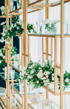 Çiçek süslemeleri ve mumlarla çok güzel bir düğün masası. Kapalı alanda düğün töreni. Bir düğün dekorunun yakın çekim detayları