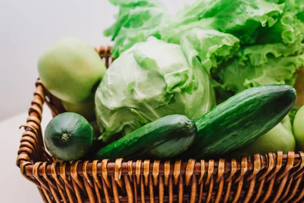 stock image Fresh green vegetables and fruits in the basket. Cucumbers, cabbage, lettuce, apples and herbal isolated on white background. Detox and green dieting. Healthy lifestyle concept. Eco life