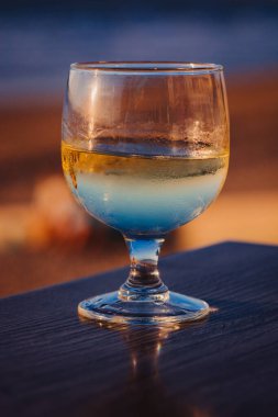 Plaj otelindeki masada bir bardak şarap. Boşluğu kopyala