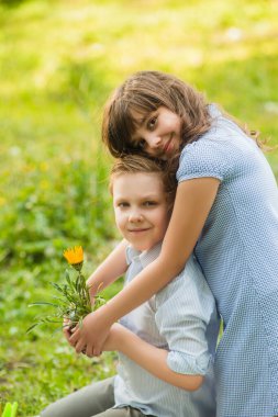 Tatlı kız ve oğlan bahçıvancılık oynuyor ve bahar bahçesinde çiçek dikiyorlar. Mutlu çocukluk