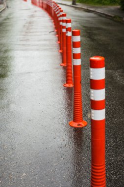 Park alanındaki çimento zeminde yaya beyaz çizgisi ve ok işaretli esnek plastik kalınlıkta yol tabelası. Apartmanın önünde kaldırım