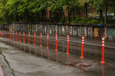 Park alanındaki çimento zeminde yaya beyaz çizgisi ve ok işaretli esnek plastik kalınlıkta yol tabelası. Apartmanın önünde kaldırım