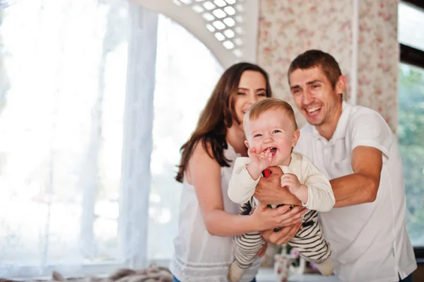 Schattige blanke baby jongen lacht op armen van ouders — Stockfoto