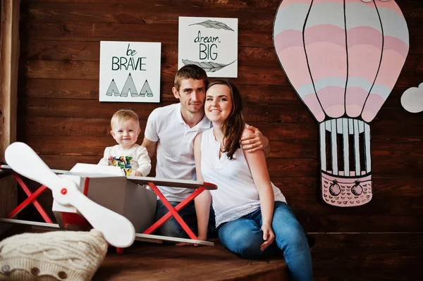 Joven caucásico feliz familia con bebé niño en la decoración plano con un — Foto de Stock