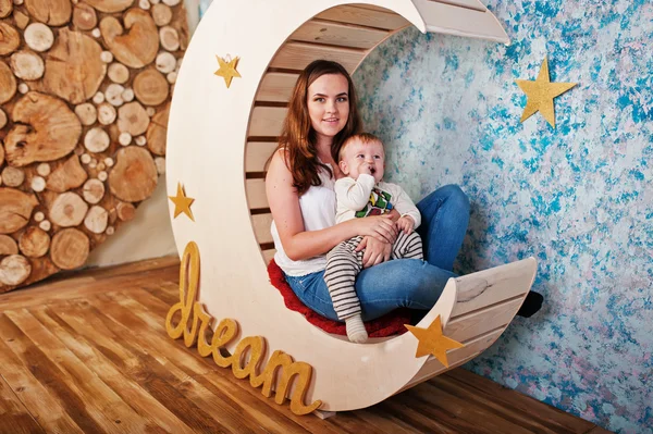 Joven madre caucásica y su bebé niño sentado en moo decorado — Foto de Stock