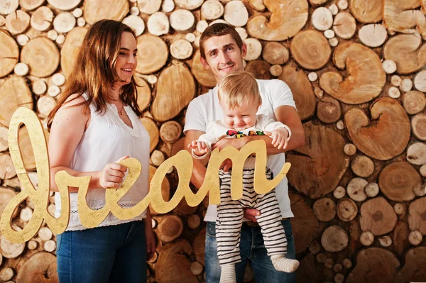 Joven caucásico feliz familia fondo madera tocones pared con — Foto de Stock