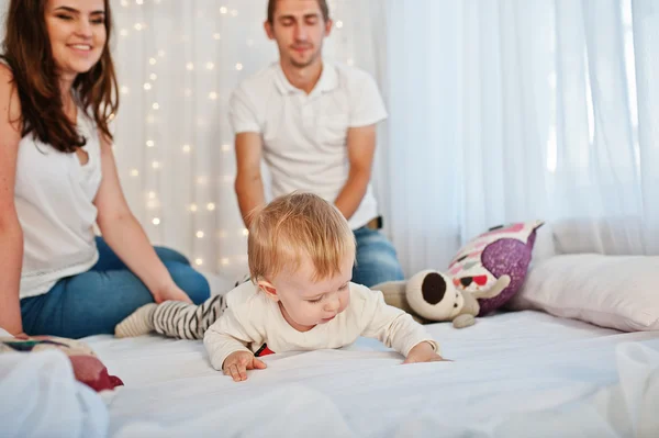 Mãe e pai com bebê menino sentado na cama branca com garlan — Fotografia de Stock