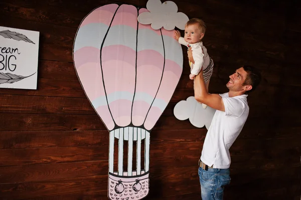 Joven caucásico feliz padre con hijo fondo madera habitación ingenio — Foto de Stock