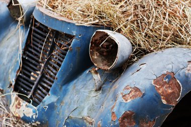 Old abandoned car with hay on engine clipart
