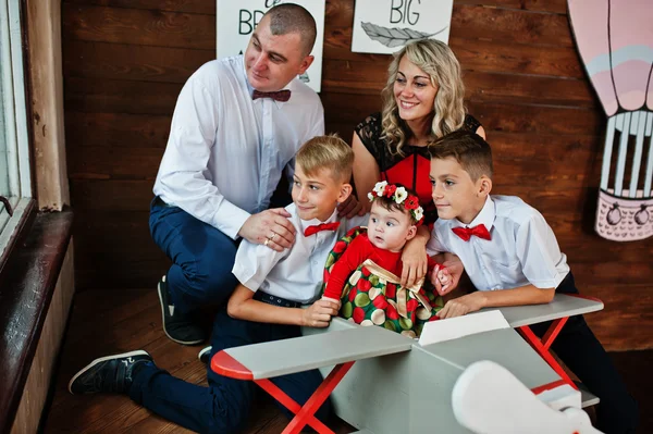 Kaukasische Familie posierte in Vintage-Studio-Zimmer Hintergrund hölzernen — Stockfoto