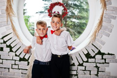 İki kardeş poz verdi Oda arka plan yuvarlak pencere