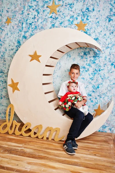 Hermanito con hermanita sentada en la luna decoración con — Foto de Stock