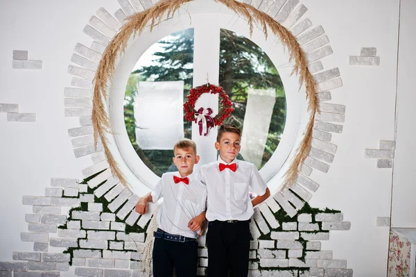 Dois irmãos posou no estúdio quarto fundo redondo janela — Fotografia de Stock