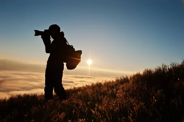 Silhouette eines Mannes Fotograf mit Kamera auf der Hand Hintergrund mo — Stockfoto