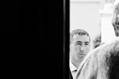 Siyah ve beyaz yan fotoğraf damat ve rahip. Düğün töreni