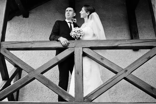 Couple de mariage rester sur le balcon près de la rampe en bois — Photo