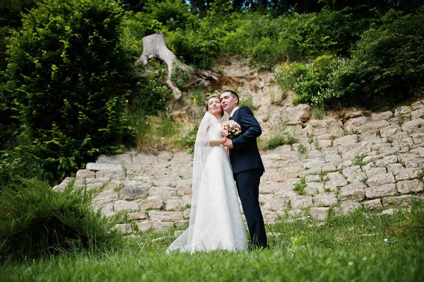 Matrimonio coppia soggiorno sfondo muro di pietra e ceppo su legno — Foto Stock