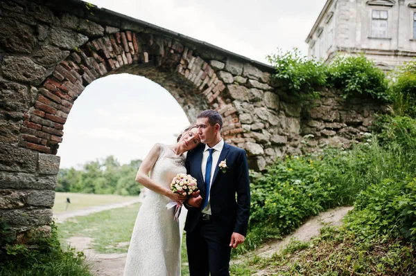 Pareja de boda bajo arco de la puerta del castillo viejo . —  Fotos de Stock