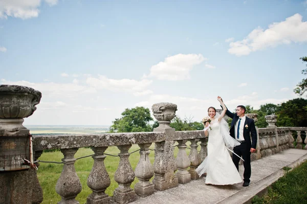 Bruidspaar in liefde in de buurt van leuningen van oude kasteel. — Stockfoto