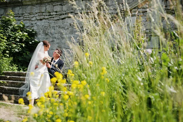 Casamento casal sentado nas escadas e olhar uns aos outros — Fotografia de Stock