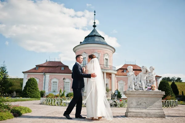 Svatební pár na dvoře staré sídlo s památkou tři chlapce — Stock fotografie