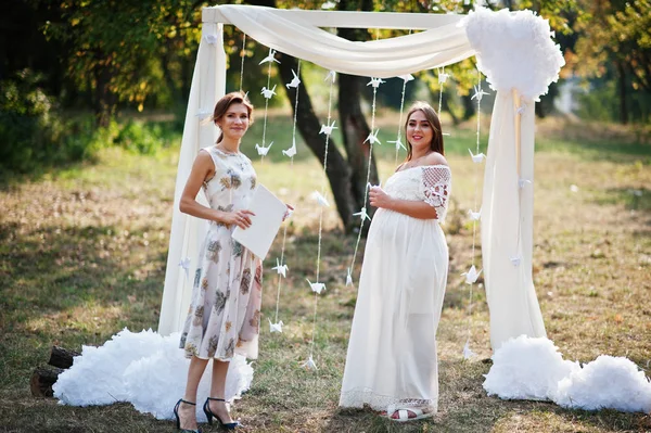 Femme enceinte avec maître de cérémonie fond décor arche — Photo