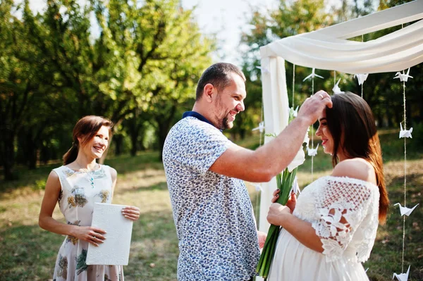 El hombre da flores para su mujer embarazada en la ceremonia — Foto de Stock