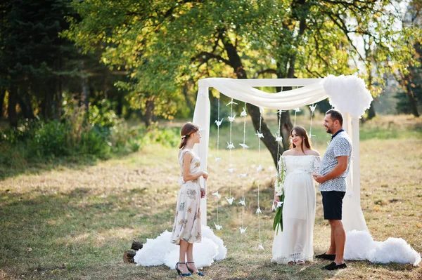 Mand med gravid kvinde og mester i ceremoni ophold baggrund w - Stock-foto