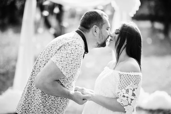 Gelukkige zwangere paar verblijf knuffelen en liefdevol in de buurt van decor arch — Stockfoto