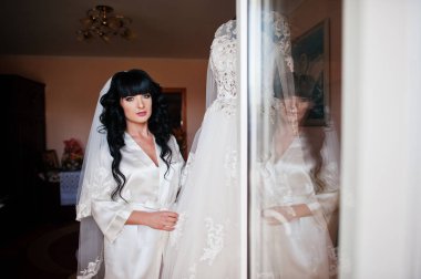 Genç sevimli esmer gelin düğün elbisesini manneq üzerinde seyir