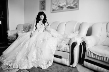 Onun odasında deri kanepede oturan güzel esmer gelin 