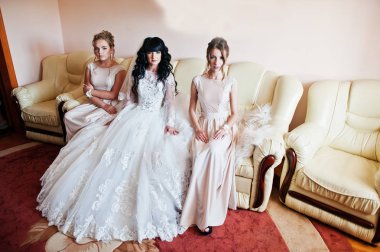 Güzel esmer gelin deri couc üzerinde oturan nedime ile